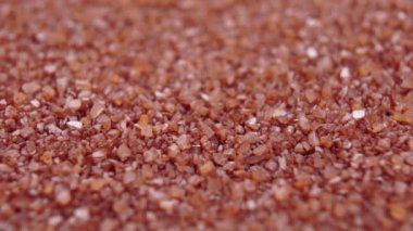 Hawaii gurme mineral deniz tuzu. Düşen kahverengi kristaller ağır çekimde yığılıyor. Döndürme. Makro çekim
