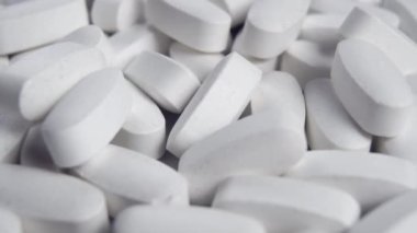 Beyaz oval ilaç tabletleri. Tıp endüstrisi konsepti. Makro. Dolly vurdu. Mavi ton