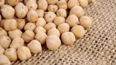 Kuru nohut, kabuklu bir çuval bezelyesinin üzerindeki tüm civciv bezelyesi. Makro. Yavaş dönüş. Cicer arietinum