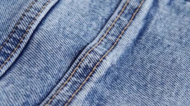 Denim kotunun dikişli mavi dokusu. Makro. Yavaş döndürme