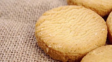 Kırsal kabarık bir çuval bezinde karamelli bisküvi. Makro. Yavaş dönüş. Taze ev yapımı kurabiyeler