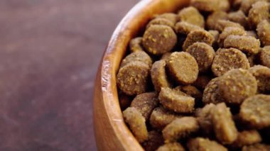 Tahta kase dolusu kuru hayvan yemi. Kedi ve köpek yemi dokusu. Sağlıklı, çıtır çıtır evcil hayvan yemeği. Makro. Yavaş döndürme