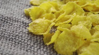 Kahvaltıda çiğ mısır gevreği. Kaba bir jüt kumaş üzerinde. Makro. Döndürme