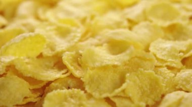 Yavaş çekimde düşen mısır gevrekleri. Makro. Döndürme. Kuru mısır gevreği. Vejetaryen sağlıklı beslenme