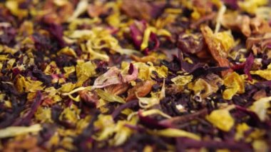 Kurumuş yapraklar ve bitkisel çiçek çayı ile meyve parçaları ve amber çiçeği. Makro. Döndürme. Sağlıklı içecek.