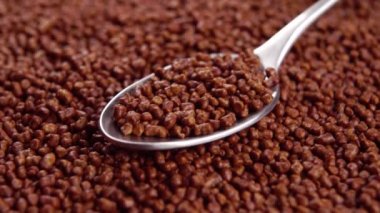 Bir çay kaşığı dolusu karabuğday çayı. Makro. Döndürme. Geleneksel Asya içeceği. Kızarmış tahıllar.