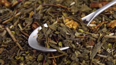 Bir çay kaşığı kurutulmuş yeşil kenevir çayı yaprakları. Doğal yasal marihuana içeceği. Makro. Döndürme