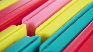 Plastik çanta klipsleri. Çok renkli mutfak kıskaçları. Makro. Döndürme. Sıraya dizilmiş renkli eğlenceli aksesuarlar
