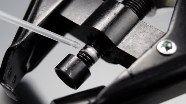 潤滑剤スプレーは スローモーションで黒糸プレスの金属機械的部分に噴霧されます マクロだ 産業技術の概念 — ストック動画