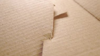 Karton teslimat kutusu. Kağıt katlarını onarıyorum. Soyut eğri yapısı. Makro. Döndürme. Geri dönüşüm paketi