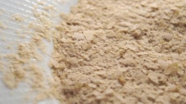 Beyaz tabakta kurutulmuş bira mayası. Vejetaryen süper yiyecekler. Sağlıklı diyet ürünü. Makro. Döndürme