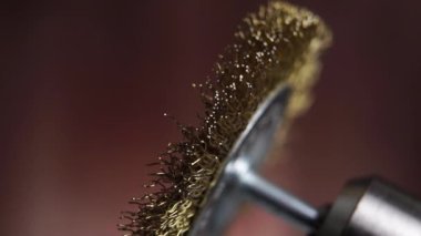 Ahşap bir arka planda matkapla pirinç tel fırça kullanmak. Makro. Yavaş çekim