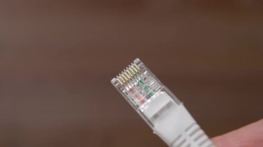 Ağ kablosu elinizin altında. Ethernet bağlantı ekipmanları. Kahverengi arka planda internet kablosu. Siber uzay kavramı