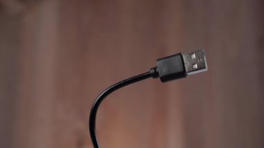 Makas siyah USB kablosunu kesiyor. Kahverengi arka planda. İnternet kısıtlamaları konsepti. Ağ kesintisi fikri