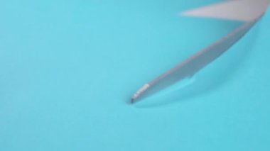 Yaratıcı sanat aktiviteleri için mavi kağıdı keskin makasla kesiyor. Makro çekim
