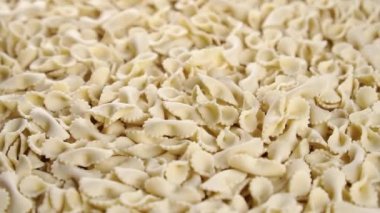 Papyonlu, pişmemiş İtalyan makarnası yavaş çekimde yığının üstüne düşüyor. Kapatın. Döndürme. Akdeniz mutfağı kavramı