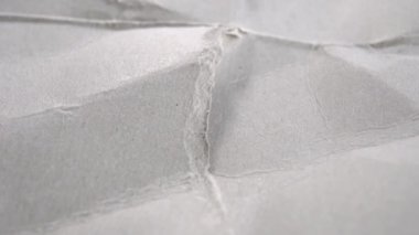 Yırtık doku, gri ambalaj kağıdı. Gri, buruşuk kartonların yırtık kenarları. Makro. Döndürme