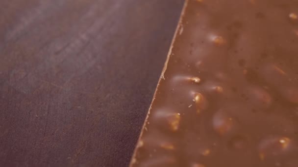 Struttura Irregolare Cioccolato Latte Con Noci Sulla Superficie Legno Macro — Video Stock