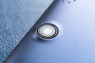 Tablet kamera lensleri kapanıyor. Dijital cihaz. Makro atış. Mavi arkaplanda