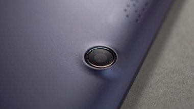 Mavi tablet web kamerası lensi gri kapağa yakın çekim yapıyor. Makro. Döndürme