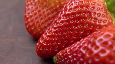 Köy ahşap bir masada taze çilekler. Olgun kırmızı böğürtlen yakından. Makro. Döndürme