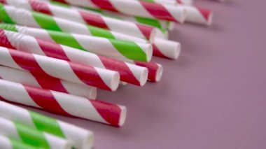 Biyolojik çözünür kağıt renkli pipetler. Pembe arka planda esnek çizgili parlak borular. Eko geri dönüşüm malzemesi. Makro. Döndürme. Parti konsepti