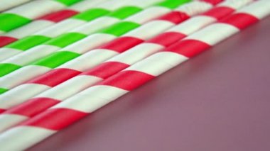 Renkli karton kağıt. Pembe arka planda yenilenebilir içme çubukları. Makro. Döndürme