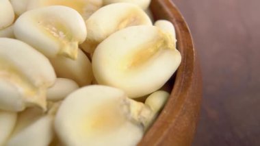 Kırsal ahşap kasede kuru mısır ezmesi yakın çekim. Makro atış. Hominy buğdayı. Döndürme