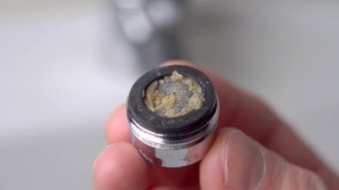 Kirli banyo musluğundaki paslı pullar yakın planda. Makro çekim