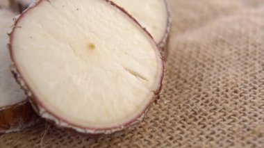 Dilimlenmiş yukka kökü. Kırsal kaba çuval bezi üzerinde ham manioc dilimler. Kurutulmuş Cassava bitkisi. Makro. Döndürme