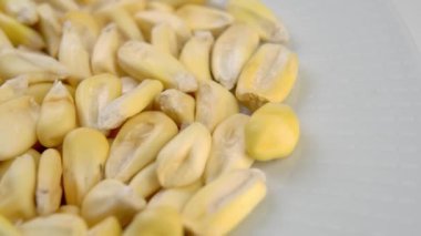 Beyaz seramik kasede mısır tohumları. Kurutulmuş mısır. Makro. Döndürme