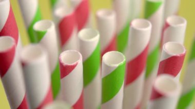 Renkli çizgili parlak kağıt, pipetleri yakın çekim içiyor. Makro. Döndürme. Doğum günü kavramı