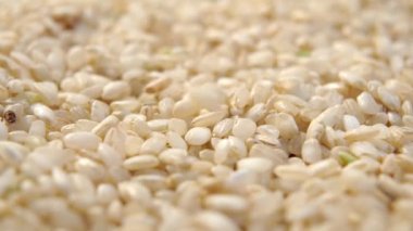İntegral, kahverengi pirinç yavaş çekimde düşüyor. Makro. Döndürme. Çiğ organik malzeme.