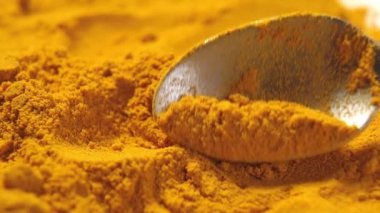 Kaşıkla ezilmiş zerdeçal kökü. Sebze sosu. Kolajenin kaynağı. Sarı çeşnili. Ağır çekimde hareket ediyor. Makro