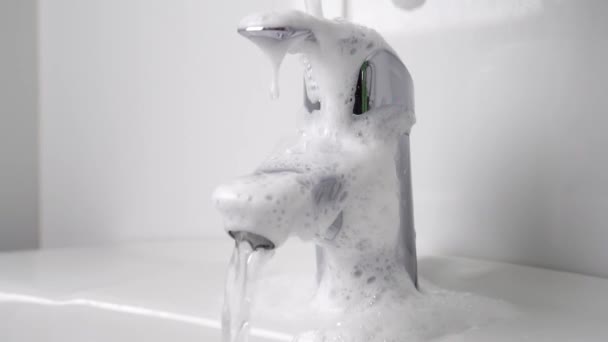 浴室打扫得很近 一只戴防护手套的手用洗涤剂泡沫冲洗水龙头 慢动作地挤压海绵 流动的自来水 卫生擦拭 家庭工作概念 — 图库视频影像