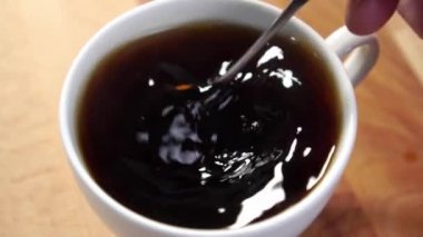 Tahta eko masanın üzerinde beyaz bardakta kaşıkla taze espresso karışımı.