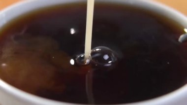 Yavaş çekimde organik bitkisel sütü bir fincan dolusu organik hindiba içeceğine ekliyorum. Makro atış. Sağlıklı gıda konsepti