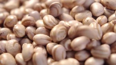 Çiğ Carioca fasulyeleri yavaş çekimde düşüyor. Brezilya baklagil taneleri. Phaseolus vulgaris. Makro. Döndürme