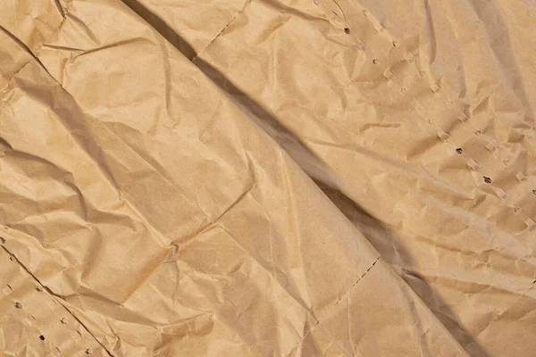 Wrapping paper crease. Wrinkled brown texture. Crumpled abstract background