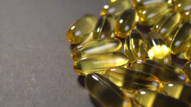 Kağıt üzerinde balık yağı takviyesi olan yarı saydam sarı Omega 3 kapsülleri. Alternatif tıp konsepti. Makro. Döndürme