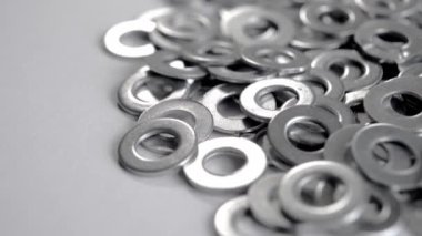 Beyaz arka planda parlak, yuvarlak, metalik, bağlayıcı çamaşır yığını. Metal çelik krom uzaylılar. Makro. Döndürme