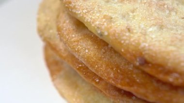 Beyaz yüzeyde şekerli tatlı ekmek. Zeytinyağlı pide ekmeği. Makro. Döndürme