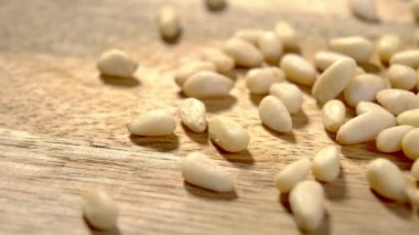 Çam fıstığı. Ahşap kırsal yüzeyde soyulmuş sedir tohumları. Makro. Dolly vurdu.