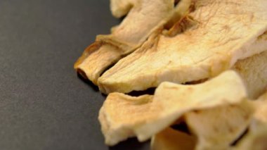 Organik kurutulmuş elma. Koyu kağıda kurutulmuş meyve dilimleri. Sağlıklı diyet yemekleri. Makro. Döndürme