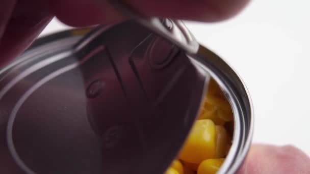 一个手指拉在戒指上打开了罐装玉米罐头的铝盖子 背景为白色 宏观射门 — 图库视频影像