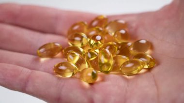 Sarı yumuşak kapsüller Omega-3. Bir avuç dolusu balık yağı hapı. Doğal takviye, yakın plan.