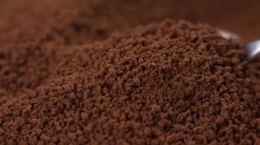 Yavaş çekimde çay kaşığından düşen granüllü kahve.