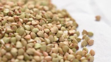 Kuru karabuğday tohumları beyaz kağıtta yakın plan büyütür. Pişmemiş taneler