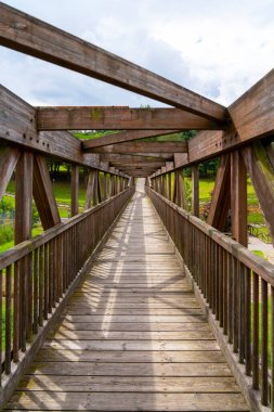 Tahta köprü, tahta köprü ve kirişler. Geometrik perspektife ve gökyüzüne sahip yaya köprüsü