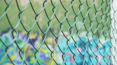 Grafiti sanatının arka planındaki metal tel örgülü tel örgü. Kentsel biçim görünümü